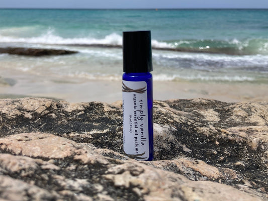 Non-toxic vanilla perfume made without synthetic fragrance, featuring Simply Vanilla essential oil perfume in a blue glass roller bottle.