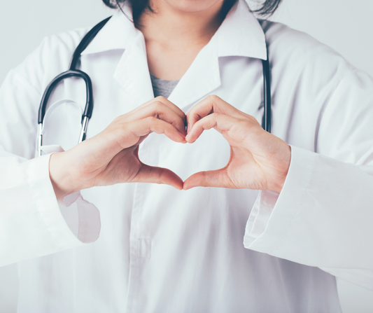 Holistic wellness practitioner making a heart with hands, symbolizing trust and recommending high-impact, low-effort products like natural deodorant