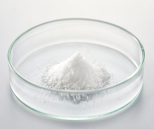 Glass dish containing a fine white powder of baking soda, highlighting its role in natural deodorant formulas to neutralize body odor and absorb moisture.