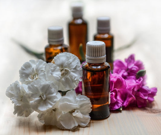 essential oil perfume made with natural ingredients, glass bottles with white and pink flowers