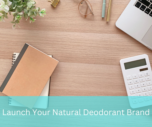Flat lay of planning workspace for how to start a deodorant business, featuring notebooks, calculator, and laptop.