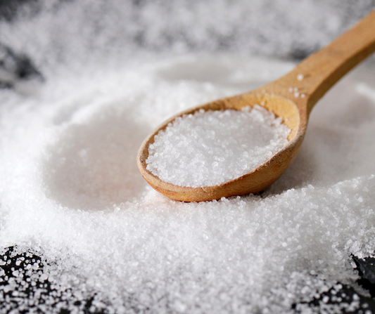 wooden spoon filled with mineral-rich sea salt for natural body exfoliation