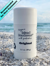 Original organic deodorant stick with probiotics in a white twist-up container, photographed on the beach in front of the ocean – aluminum-free, unscented, and handcrafted by Island Deodorant