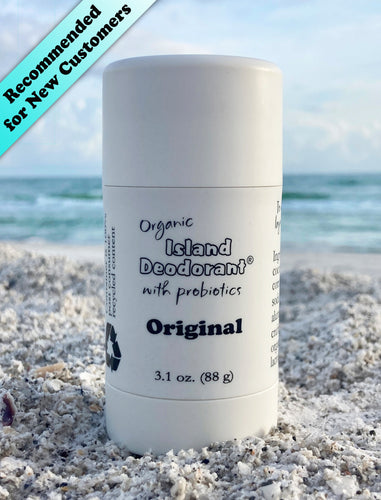 Original Stick Deodorant with Probiotics, in white plastic twist up container, on the beach in front of the ocean