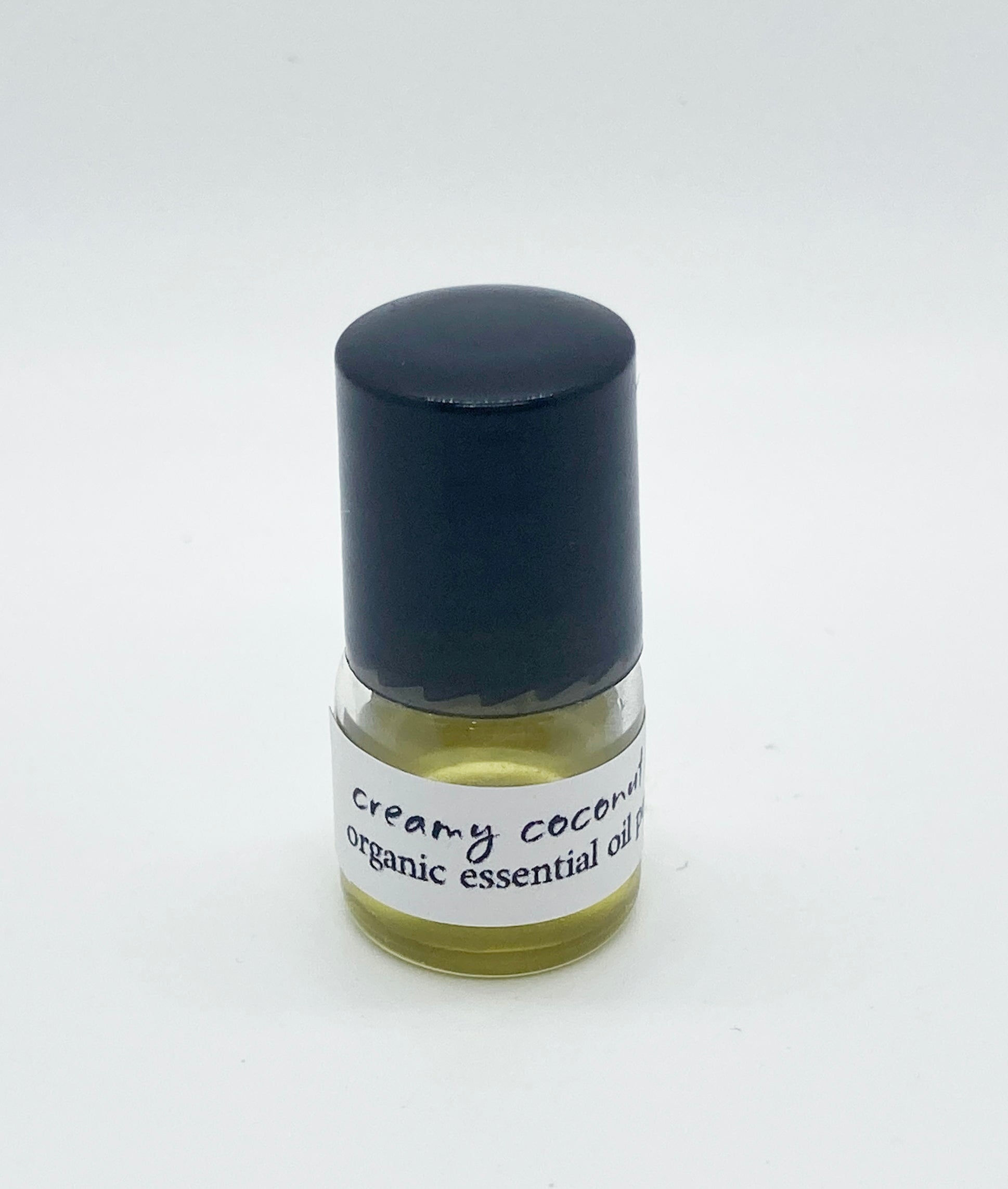 1ml sample bottle of Creamy Coconut Lime organic essential oil perfume with a black cap, shown against a white background.
